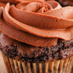 Close-up of a chocolate brownie cupcake with swirled frosting and text: Decadent Brownie Cupcakes made with the finest brownie mix.