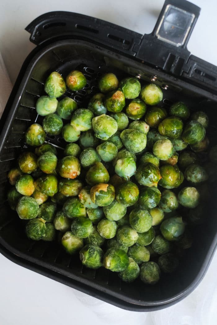 Frozen brussel sprouts air fryer-ready in a basket, perfect for quick and easy cooking.