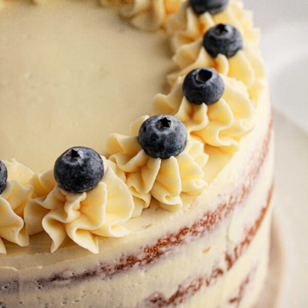 A luscious cake crafted with muffin mix, topped with frosted blueberries and cream decorations.