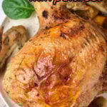 An instant pot whole chicken with crispy skin sits on a plate, accompanied by tender potatoes and fresh spinach leaves.