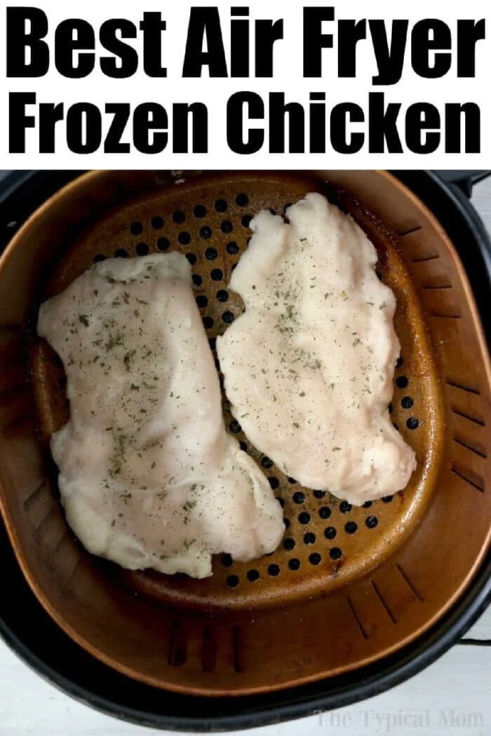 Two raw, seasoned chicken breasts&mdash;or even a frozen chicken breast&mdash;sit in an air fryer basket, ready to be cooked.