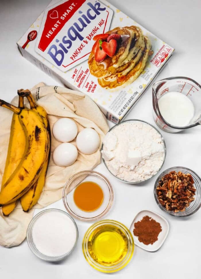 Ingredients for banana nut pancakes, inspired by a Bisquick banana bread recipe, including Bisquick mix, bananas, eggs, milk, flour, pecans, and spices.
