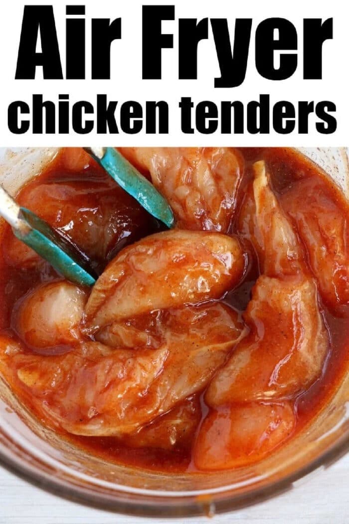 Raw chicken tenders being coated in marinade with tongs in a glass bowl, labeled Air Fryer chicken tenders no breading.