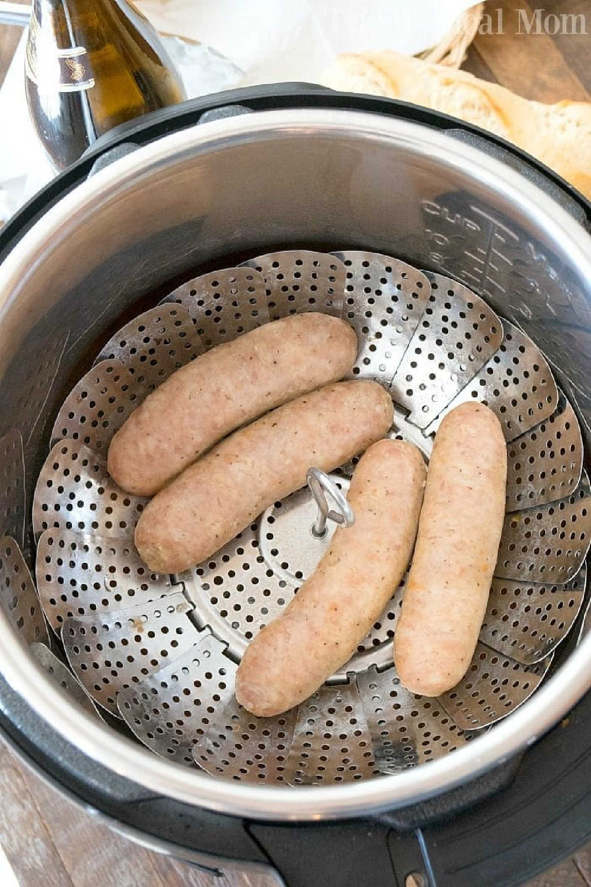 Instant Pot brats and sauerkraut taste amazing! Easy way to steam bratwurst or sausage with some beer in your pressure cooker for dinner. #instantpot #pressurecooker #brats #bratwurst #sausage #instantpotrecipes #ninjafoodi Four raw instant pot brats rest on a metal steamer basket inside an Instant Pot, ready to cook.