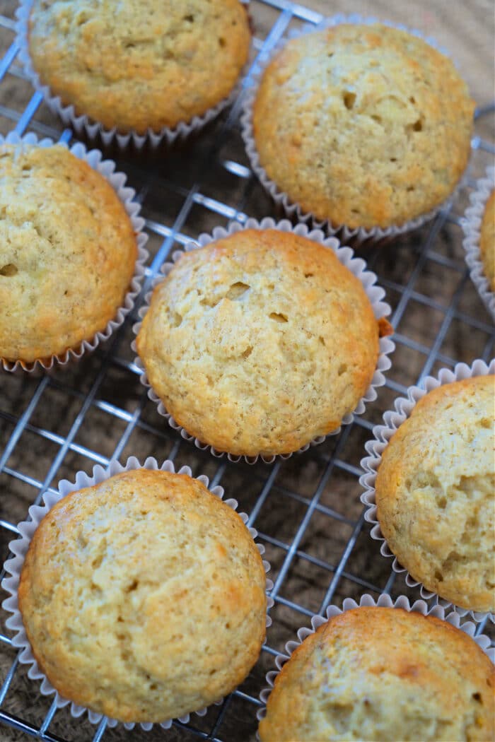 Freshly baked banana muffins in paper liners cooling on a wire rack—perfect for trying out your favorite banana muffin recipe.