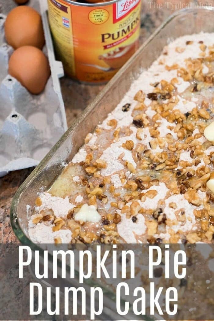 Glass pan with unbaked pumpkin pie dump cake topped with walnuts sits beside eggs and a can of pumpkin puree.