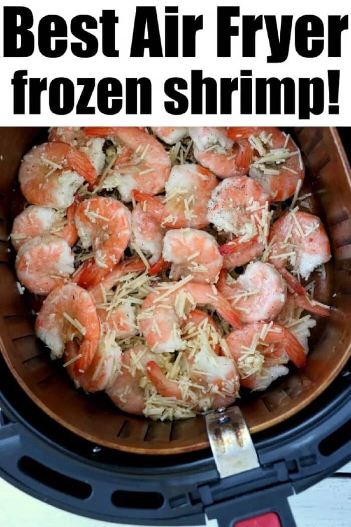 Air fryer basket filled with air fryer frozen shrimp, topped with shredded cheese and seasoning for a quick, delicious meal.