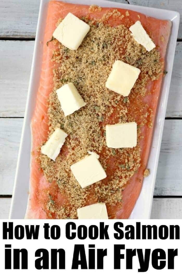Salmon in the air fryer comes out amazing! With a sweet glaze on top cooking fish in a Ninja Foodi or other brand is easy and a healthy dinner you'll love. #ninjafoodirecipes #salmon #airfryerrecipes #airfryersalmon #fish #foodi #ninjafoodi #thetypicalmom Raw salmon fillet topped with brown sugar and butter on a white tray, ready to show you how to make delicious salmon in the air fryer. Text: How to Cook Salmon in an Air Fryer.