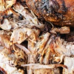 Close-up of juicy, shredded pork roast in oven with crispy edges, fall-apart delish.