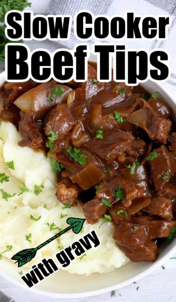 Bowl of slow cooker beef tips in rich gravy with mashed potatoes, garnished with parsley, text overlay says Slow Cooker Beef Tips.