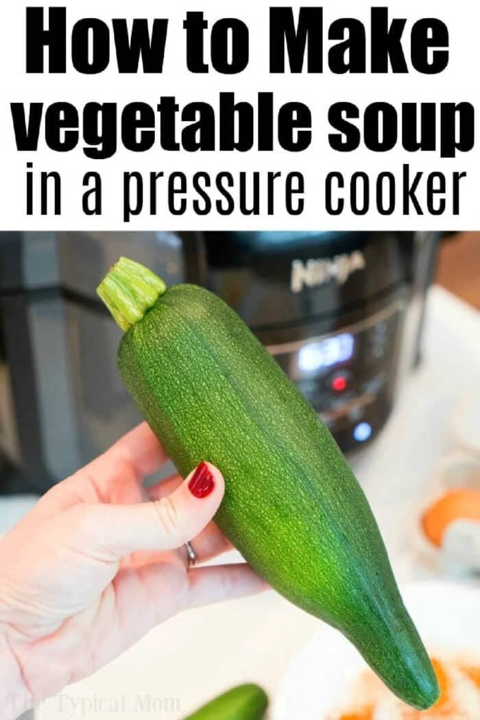 A hand holds a fresh zucchini in front of a pressure cooker with text about making easy Instant Pot minestrone soup.
