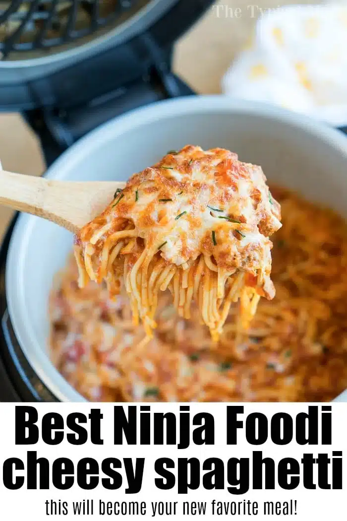 A wooden spoon lifts cheesy spaghetti from a pot, with melted cheese and sauce visible&mdash;a delicious example of ninja pressure cooker recipes.