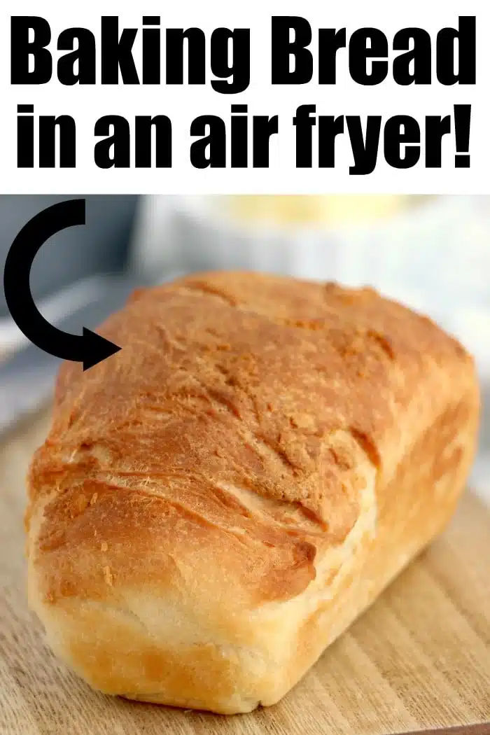 A loaf of golden-brown air fryer bread rests on a wooden board with text: Baking Bread in an air fryer!.