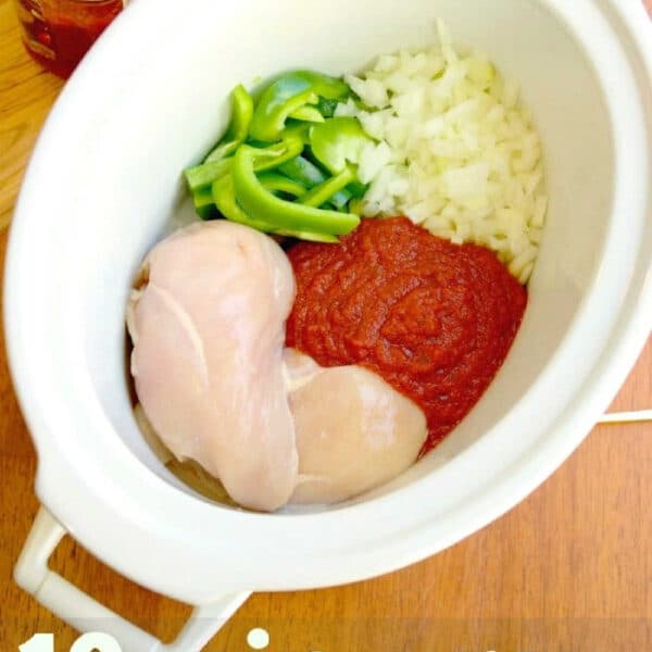 Uncooked chicken, tomato sauce, chopped onions, and green peppers in a slow cooker—everything you need to prep classic crockpot chicken cacciatore.