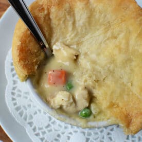 A bowl of chicken pot pie with flaky crust, filled with creamy sauce, chicken, peas, and carrots—just like a classic KFC Chicken Pot Pie recipe.