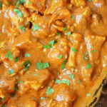 Close-up of creamy Slow Cooker Chicken tikka masala garnished with chopped cilantro.