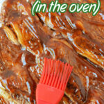 Red brush applying sauce to beef riblets on a tray, with text: The Best Beef Riblets (in the oven). Perfect for any Riblets Recipe or Beef Recipe craving!.