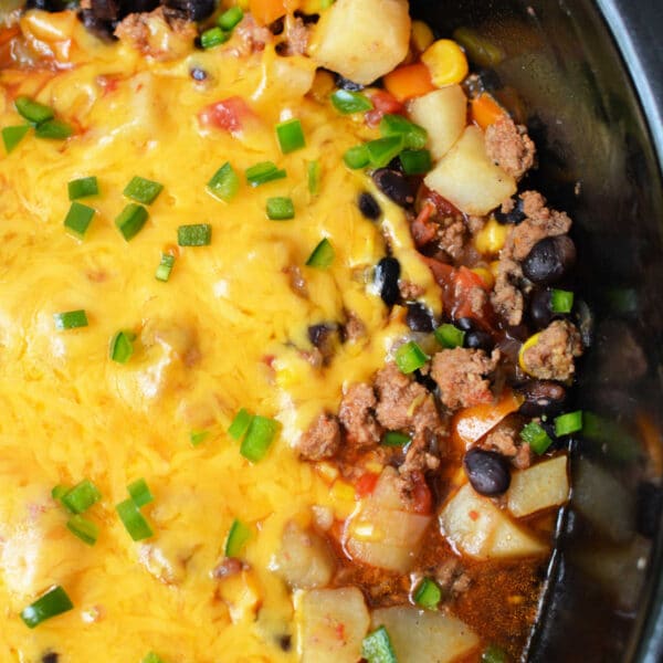 Enjoy this hearty Cowboy Casserole Crockpot dishโcheesy ground beef, potatoes, black beans, corn, and green onions all slow-cooked to perfection.