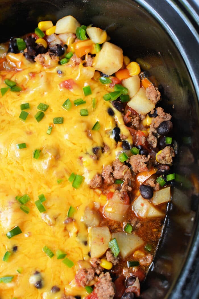Enjoy this hearty Cowboy Casserole Crockpot dish—cheesy ground beef, potatoes, black beans, corn, and green onions all slow-cooked to perfection.
