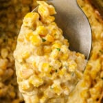 A spoon scooping creamy Crockpot Creamed Corn from a crockpot, with text reading Crockpot Creamed Corn.