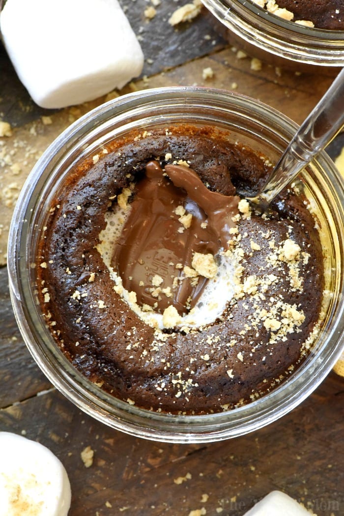 Chocolate cake in a jar with a melted center, topped with crumbs, and a spoon digging in—this dessert is the perfect example of how boxed cake mix recipes can be elevated to something irresistibly decadent. Fluffy marshmallows nearby add a playful touch.