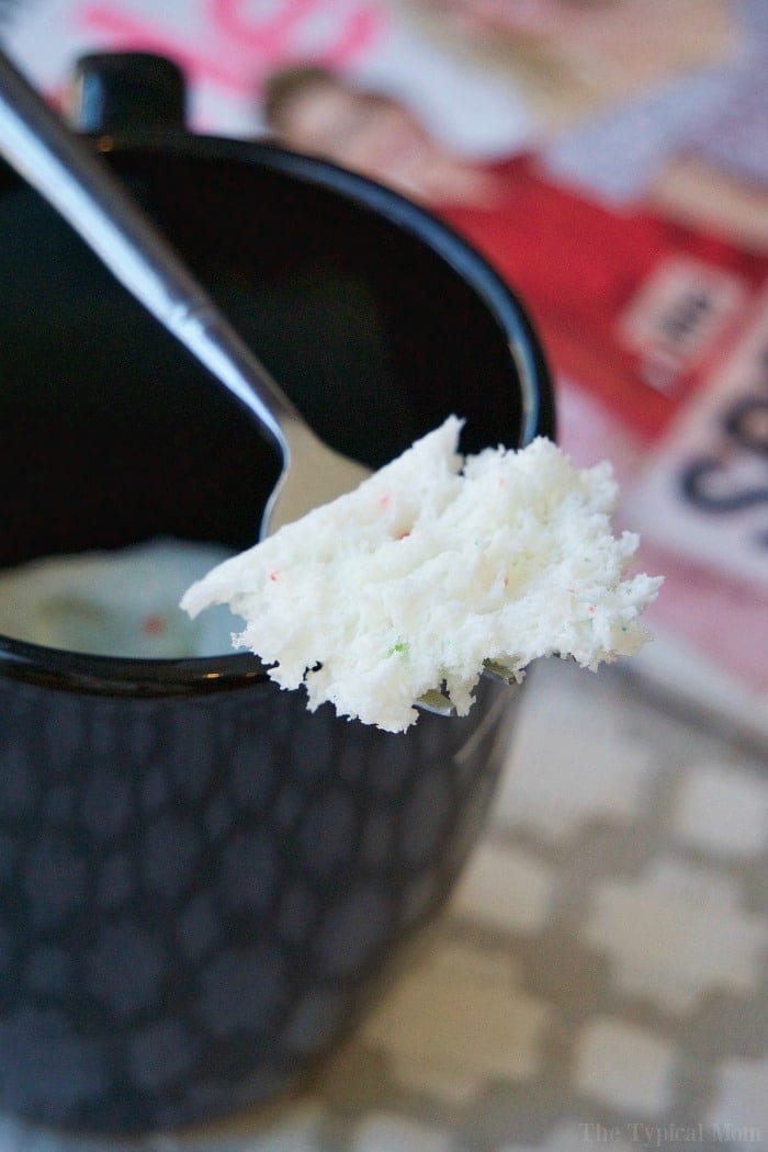 A spoon holds a fluffy bite of cake above a black mug, the result of one of those clever boxed cake mix recipes, with magazines blurred in the background.